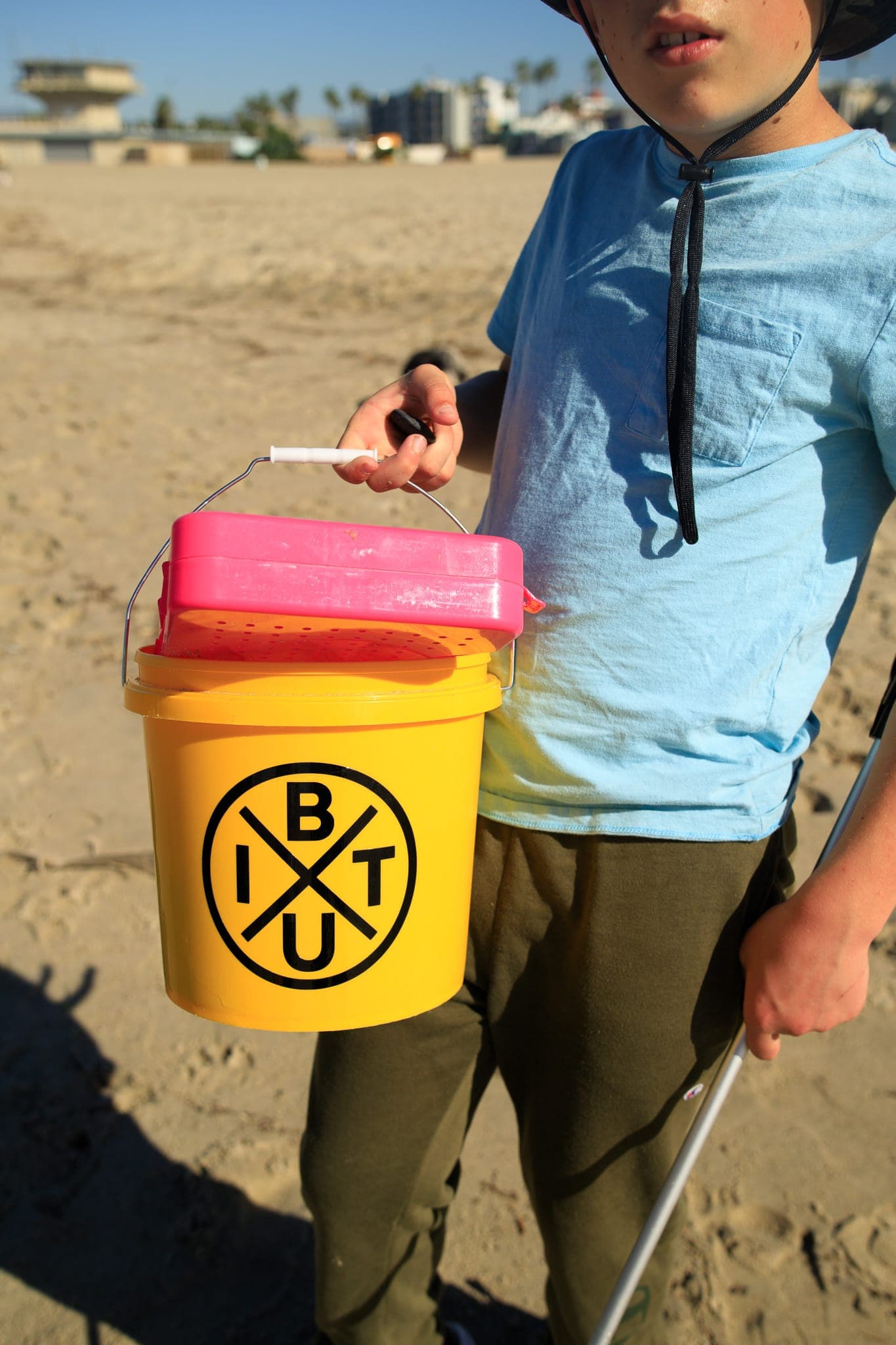 IBTU branded bucket during Coastal Care beach cleanup at Venice Beach